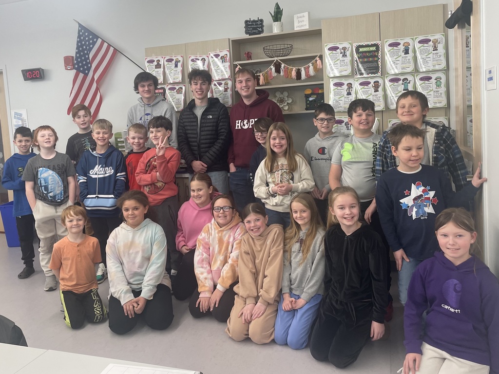 Fourth graders posing for a picture with high school students.