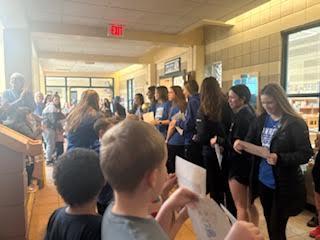 Pictures of students visiting the girls high school basketball team and celebrating their victory. 