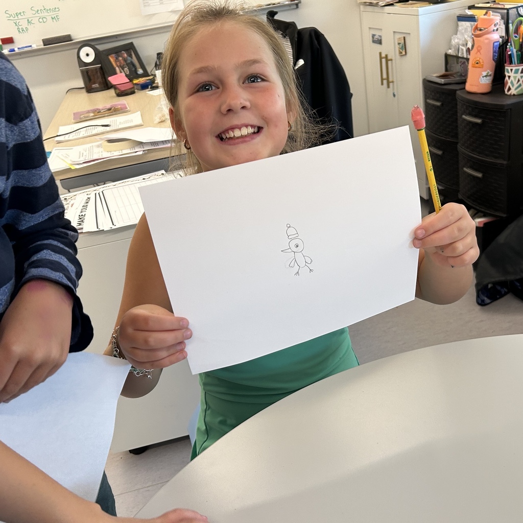 Female student holding up a small drawing.