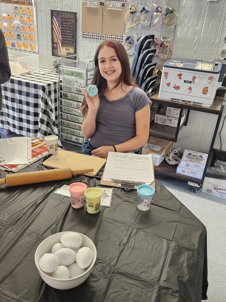 7th Grade Social Studies - learning about the Middle Colonies. A female student shows a faux bakery item she has rolled out and "baked".