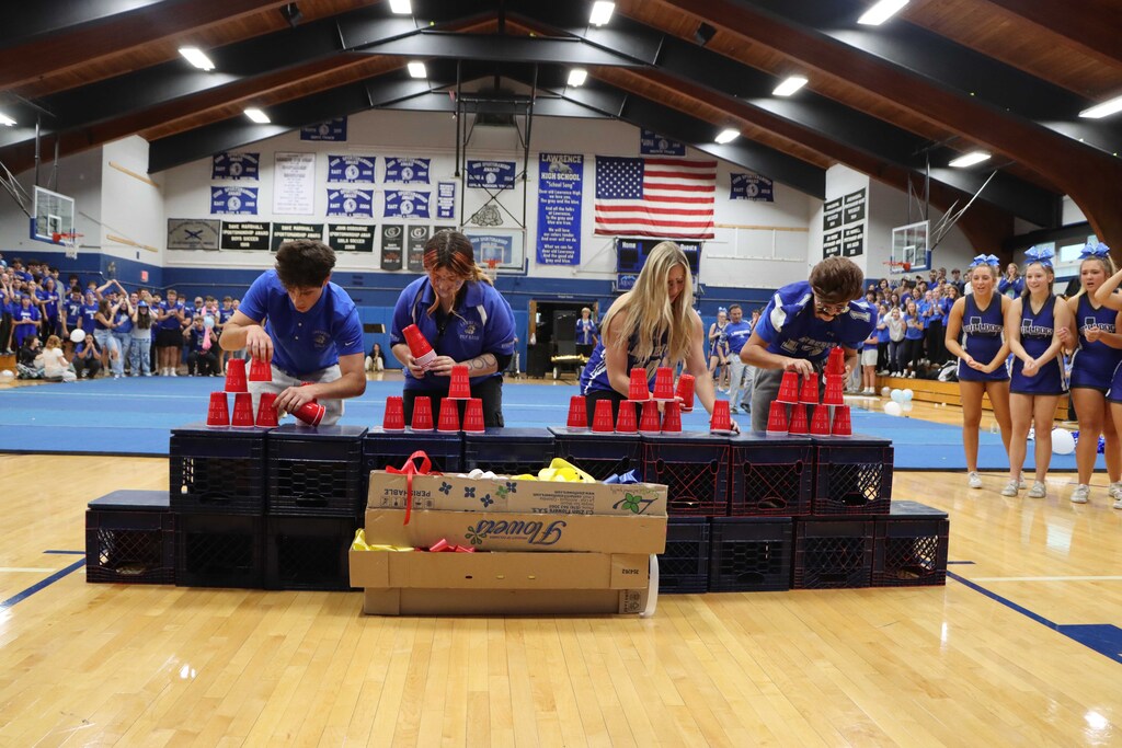 Four students stacking cups in a pep rally game