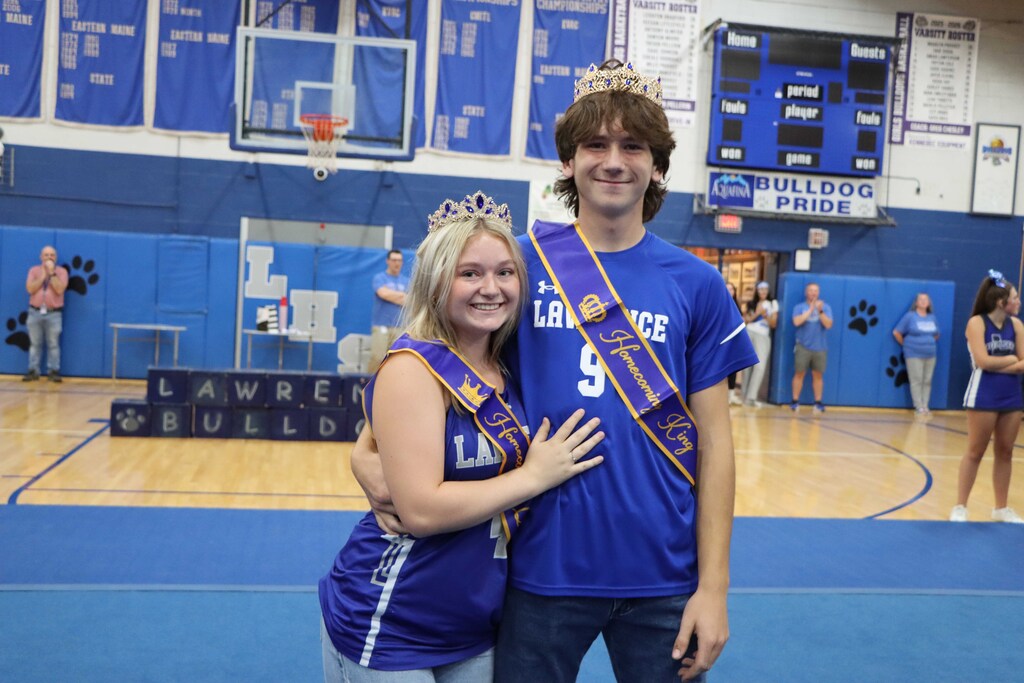 Homecoming King and Queen posing with their crowns and sashes.