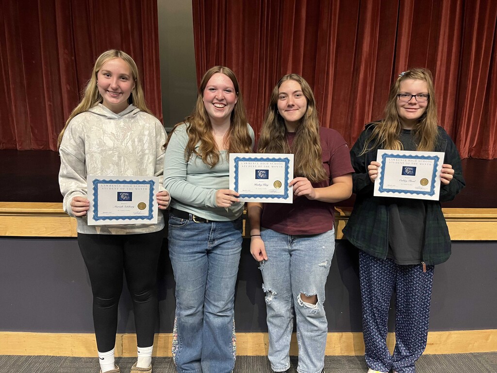 Freshman, sophomore, junior, and senior students of the month are standing holding their certificates of achievement. 