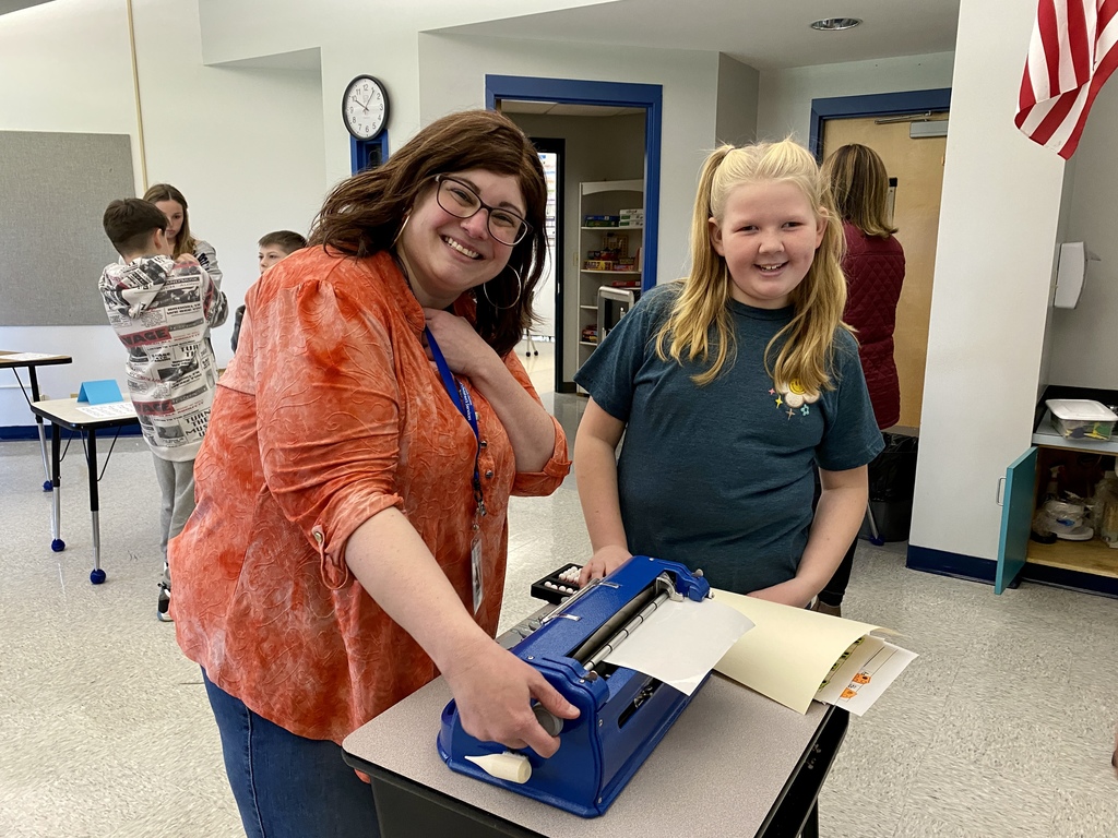 MRS Erin and a student posing for a picture during a brail reading class.