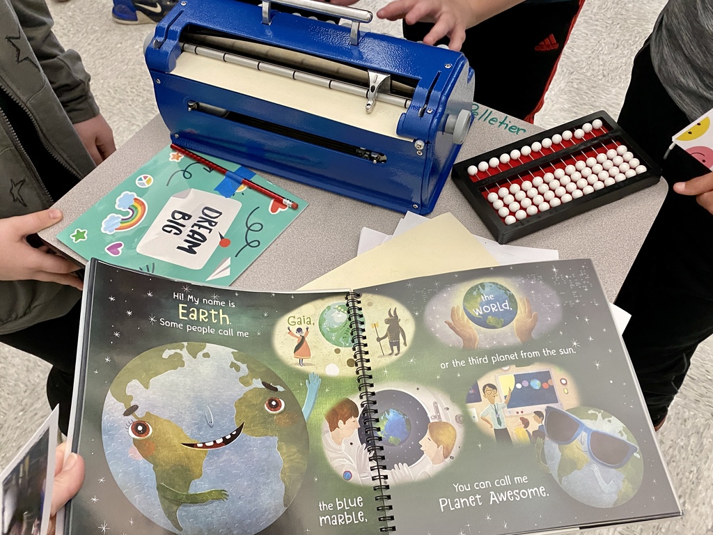 Picture of a brail machine and books that were customized with students names written in brail