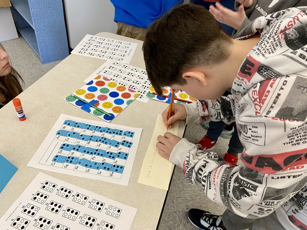 Students involved in activities associated with learning to read brail.