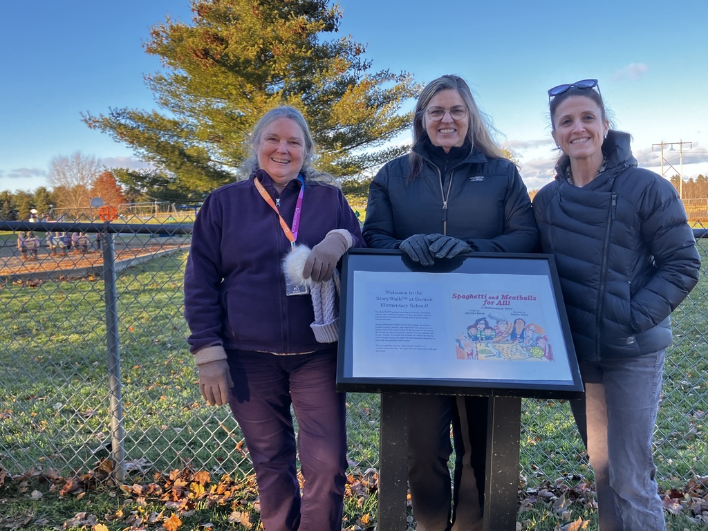 Teachers posing for a picture while on the story walk.