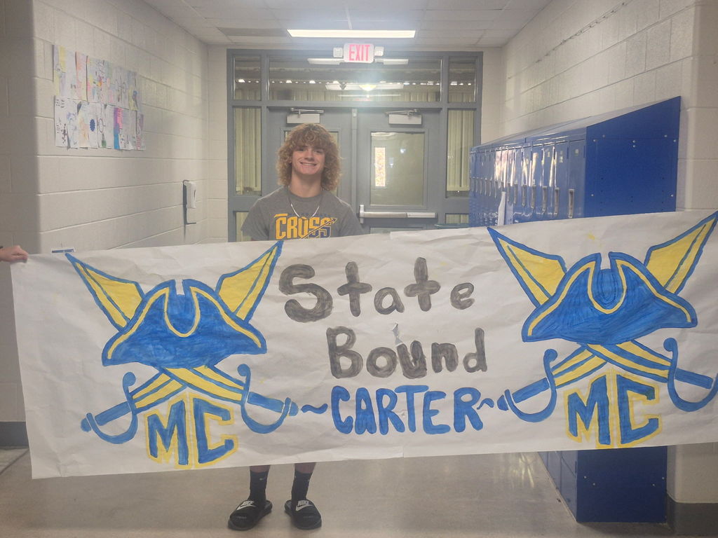 Carter stands behind a banner made that says he is Statebound