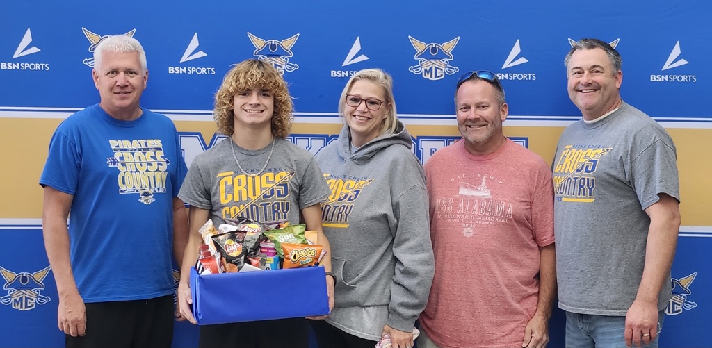 Coaches and parents pose with Carter before he heads to State