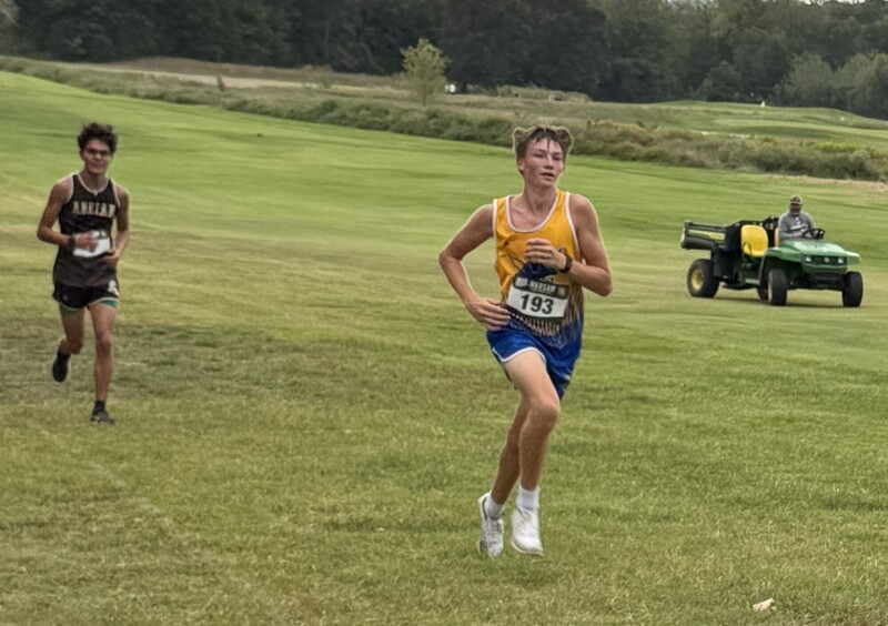 Fisher is running in this photo with another runner chasing.