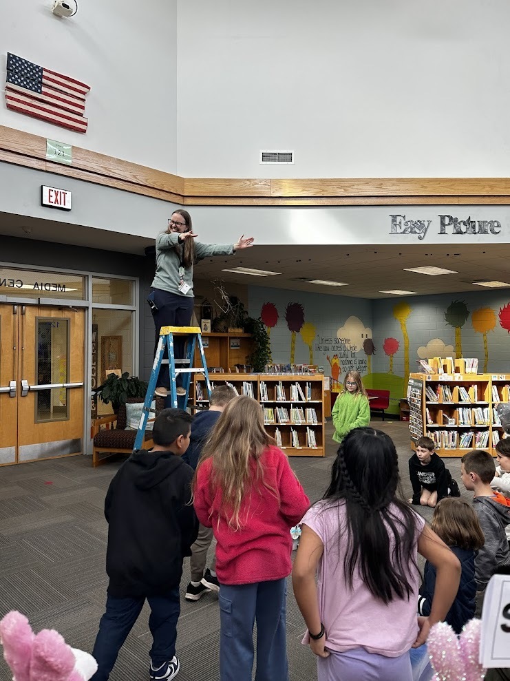 Mrs. Norton dropping an egg from the top of the ladder.
