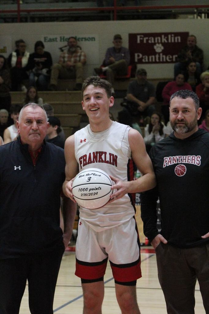 Basketball player, with coach and family member