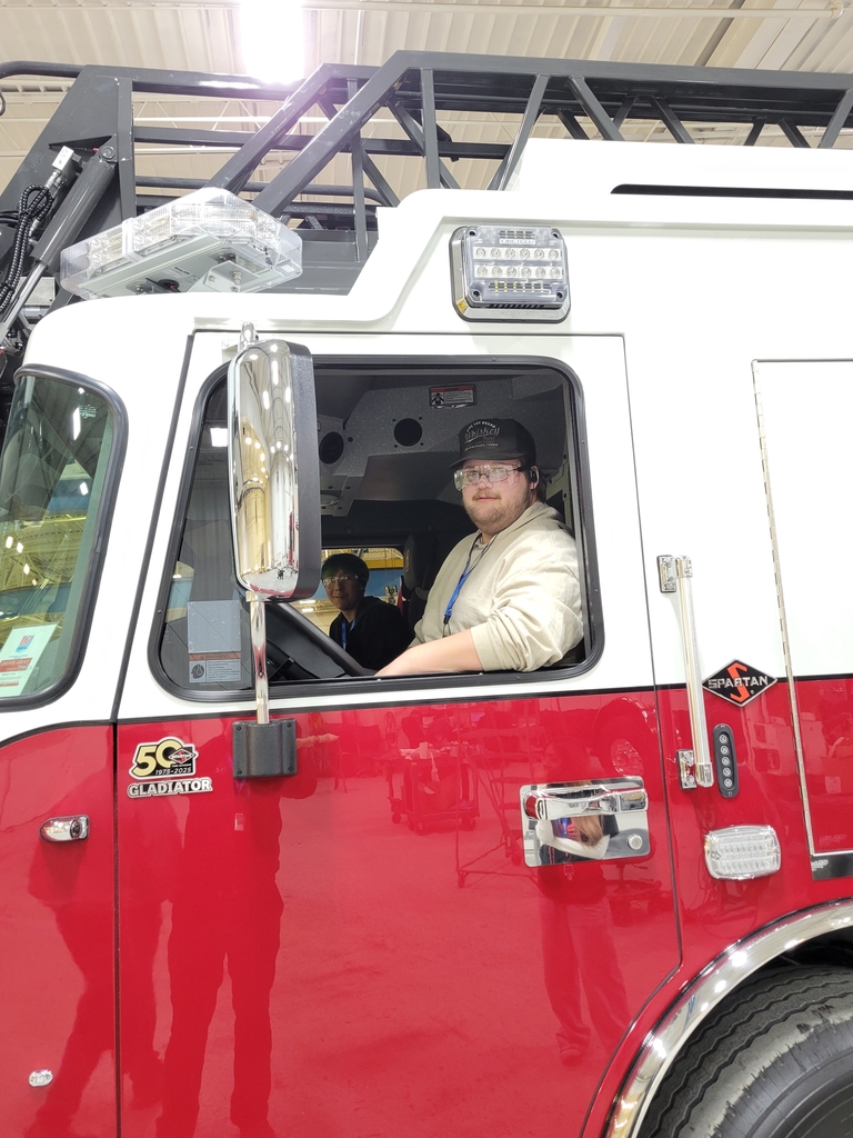 Students getting to check out the inside of a brand new firetruck.