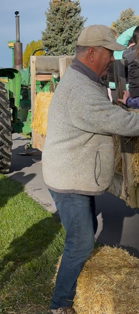 Man Helping Kids Off Of A Tractor