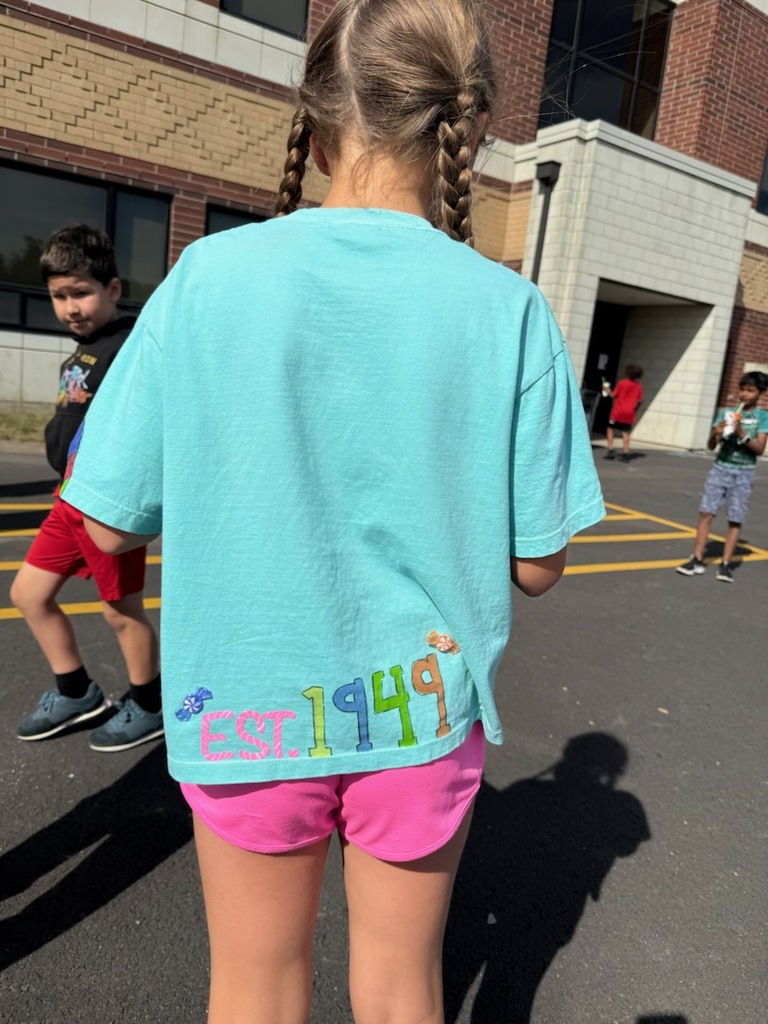 The student faces the other way to show the back of their Candyland shirt