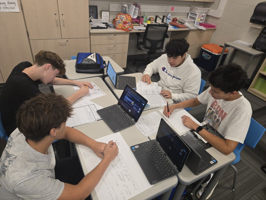 Four students work at their desks
