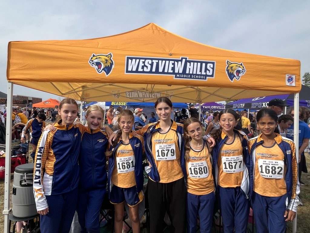 The girls cross country team smiles at the camera