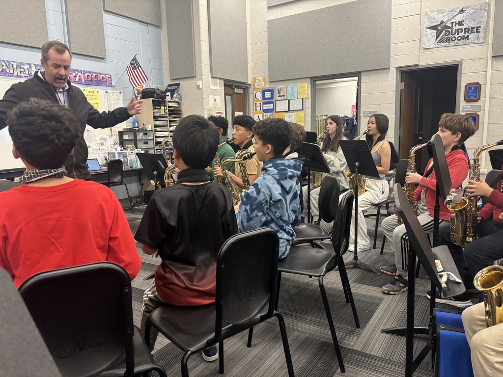 Students sit with their instruments as they learn from Shawn Maxwell
