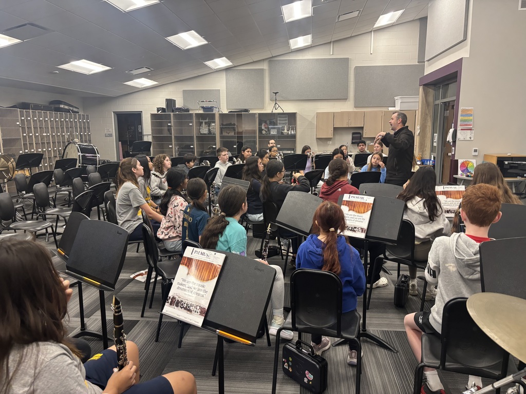 Students sit with their instruments as they learn from Shawn Maxwell