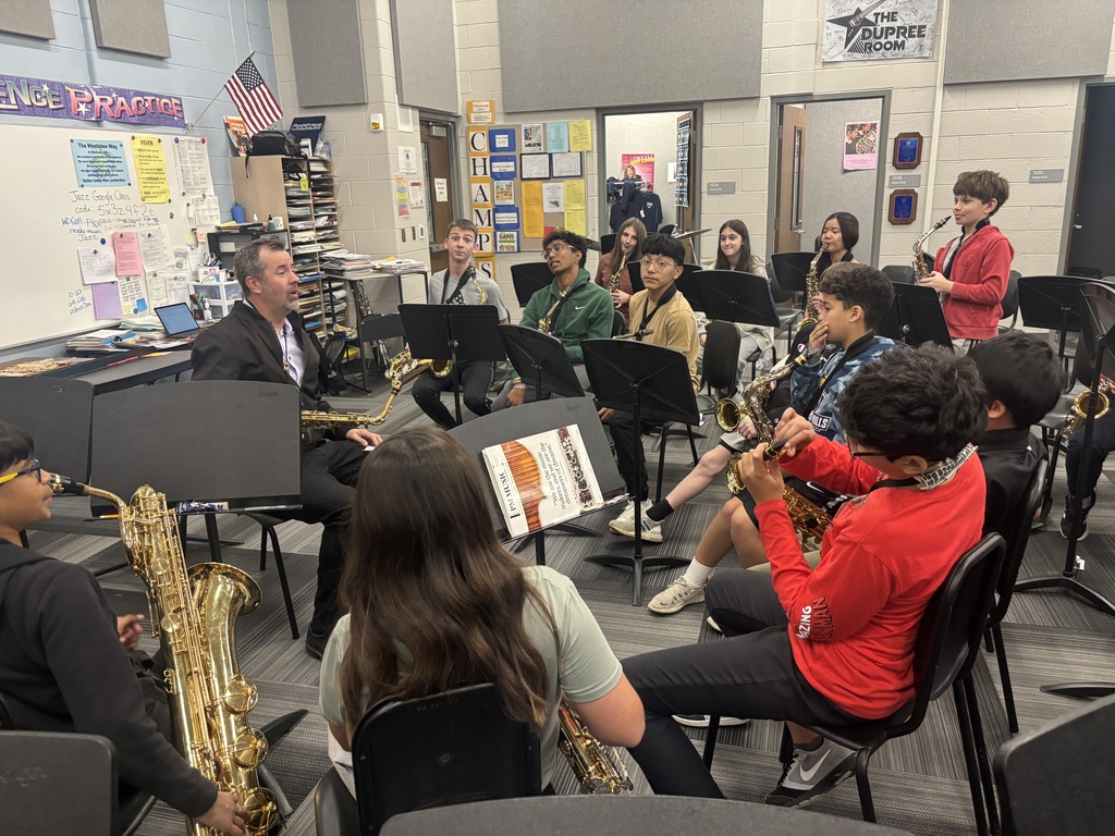 Students sit with their instruments as they learn from Shawn Maxwell