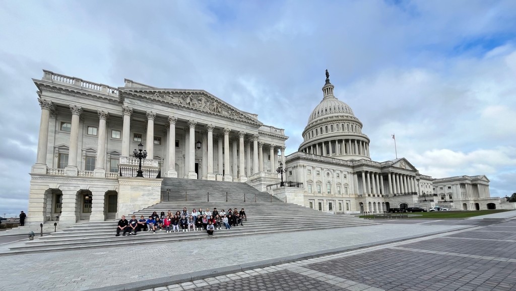 Students sit on the steps of the Capitol building
