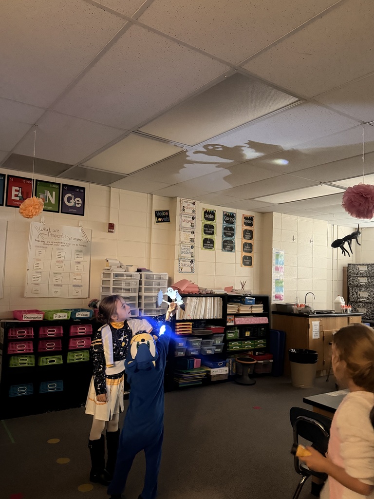 Students make shadows around the room using paper and flashlights