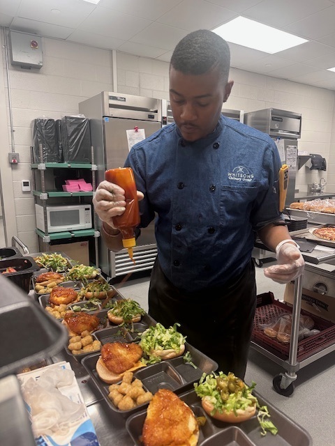 Chef cam puts  sauce on sandwiches