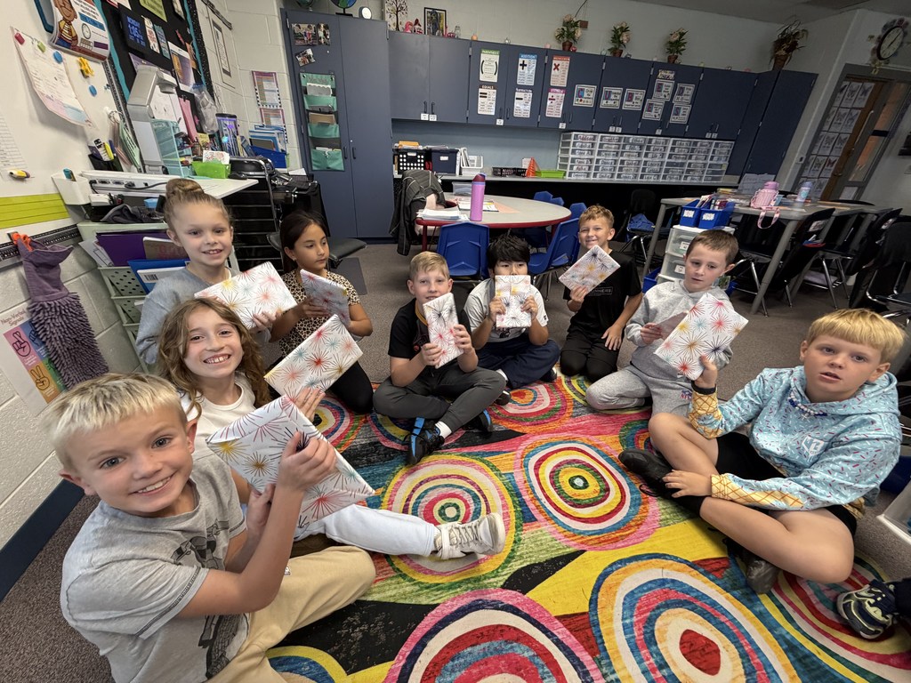 Students smile holding up their new journals