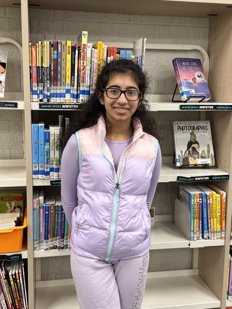 Student standing in front of books