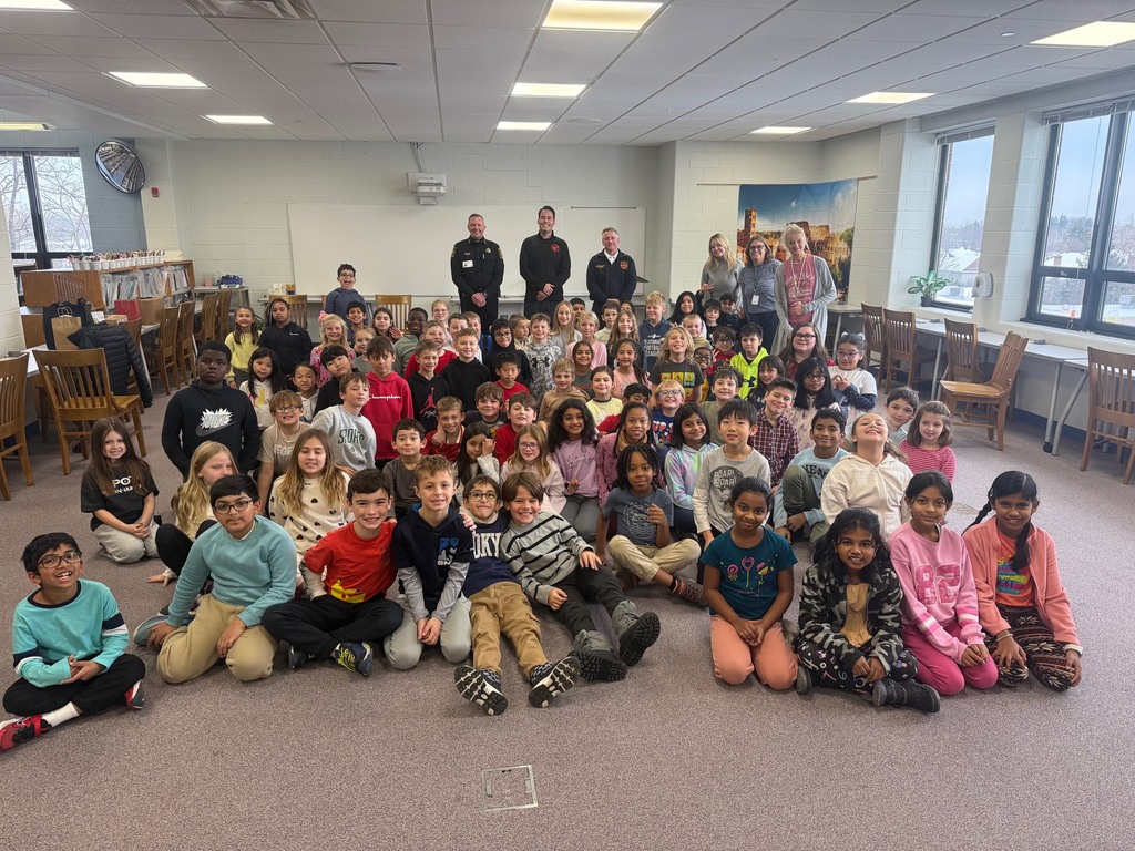 The class sits and smiles with the Mayor of Westmont, Police Chief, and Deputy Fire Chief