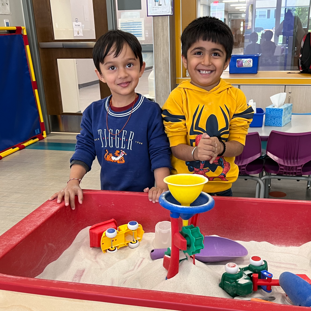 Preschoolers smile and play with a sandbox