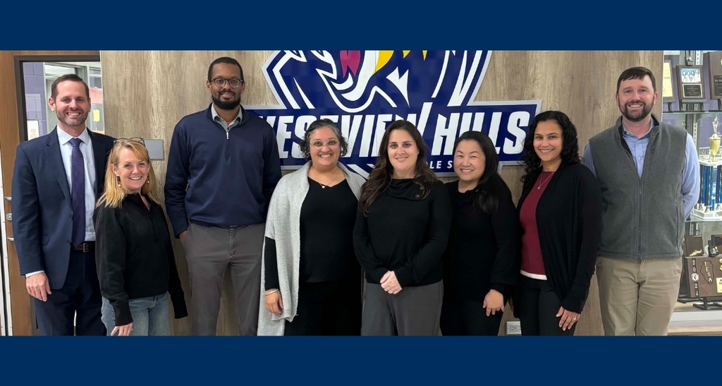 The Board of Trustees stands and smiles together