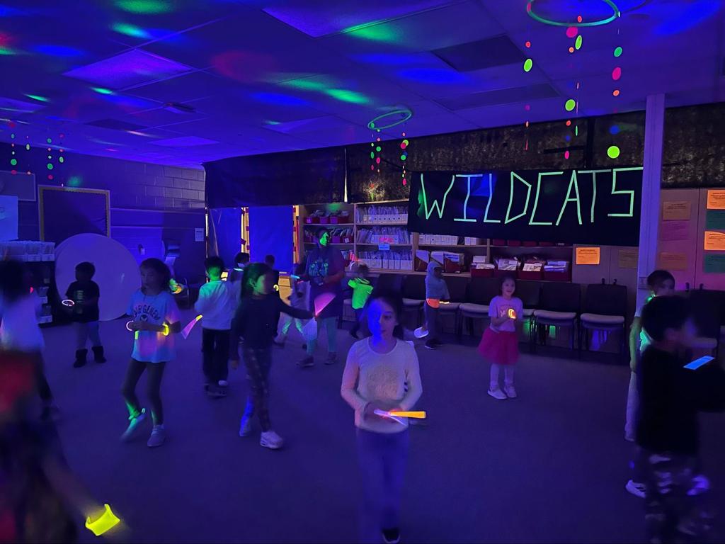 Students dance with glow sticks and neon lights