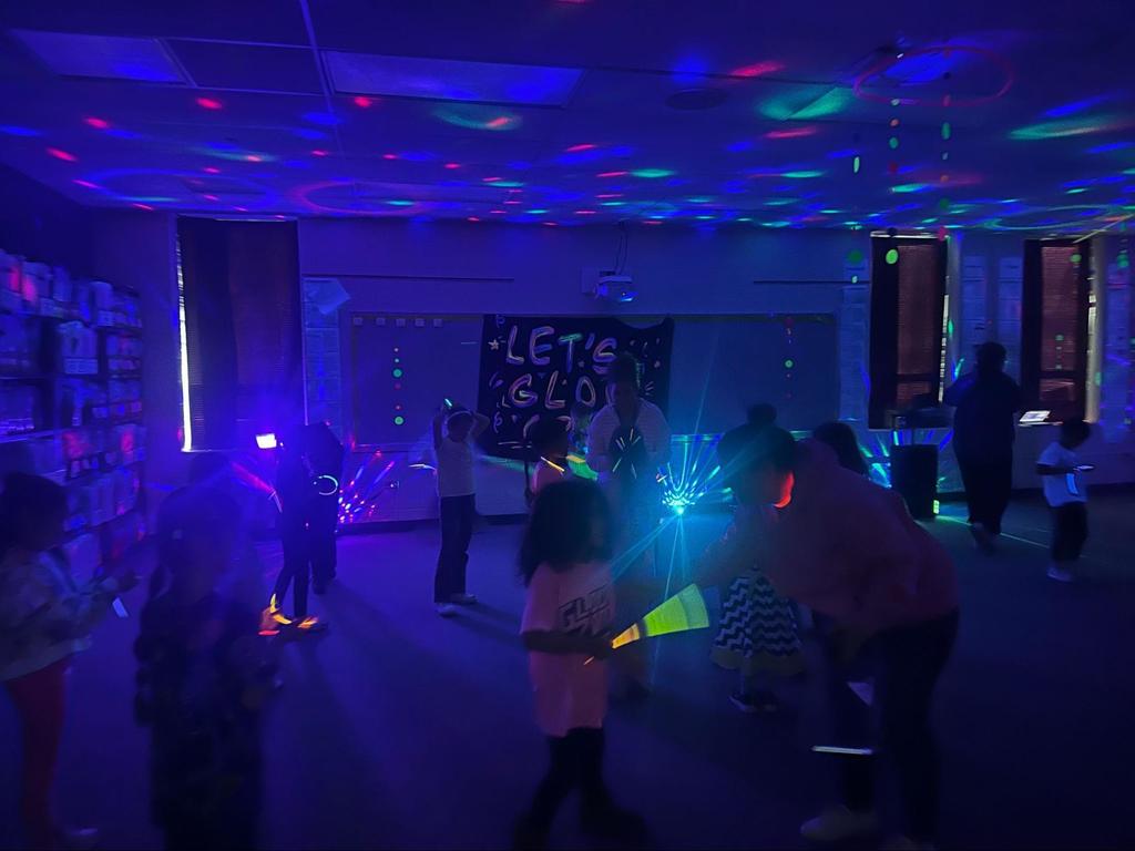 Students dance with glow sticks and neon lights