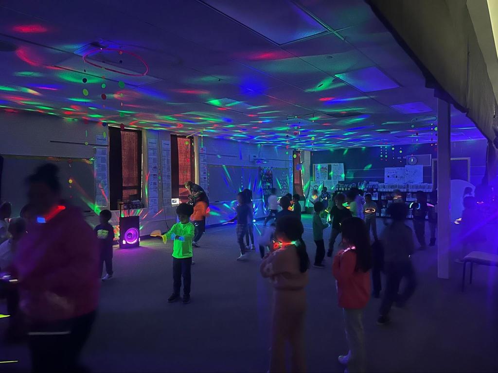Students dance with glow sticks and neon lights