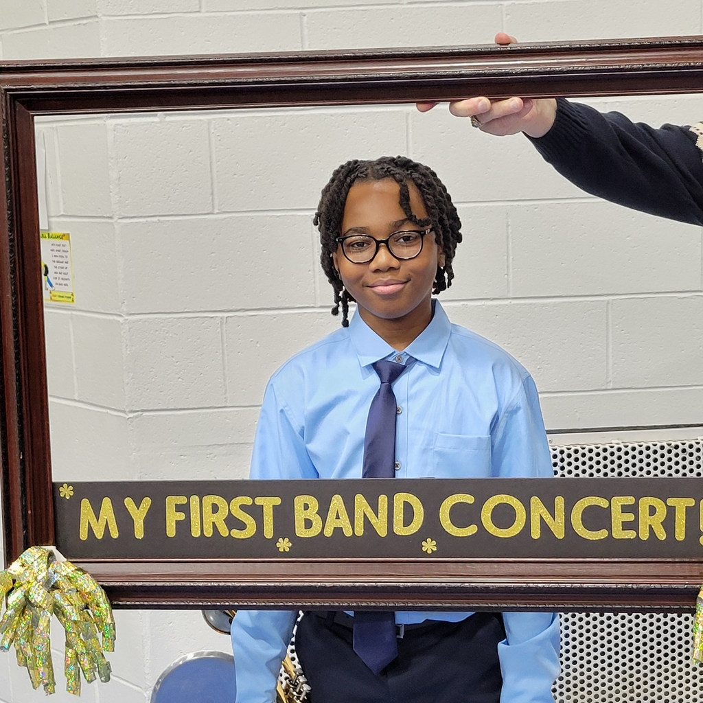 Students smile behind a picture frame with the words, "My first band concert"