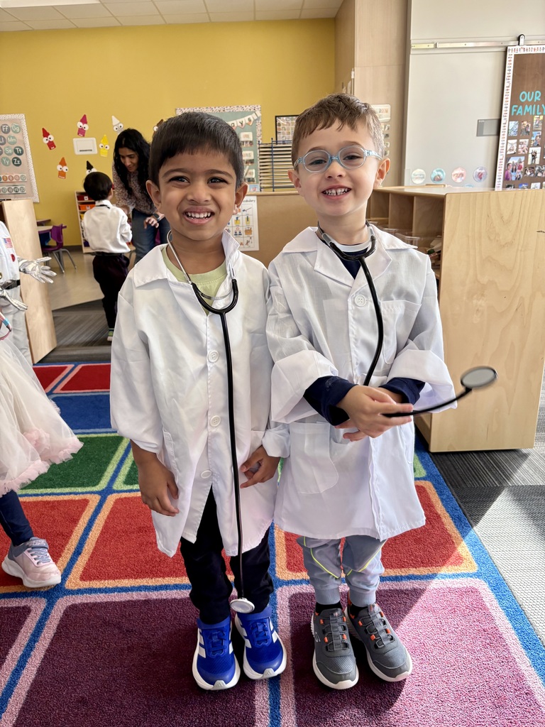 Preschoolers pose in uniforms for the jobs they want. Two students are dressed as doctors.
