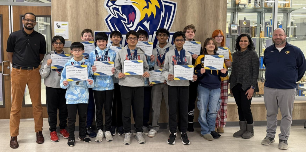 The chess team poses with members of the board