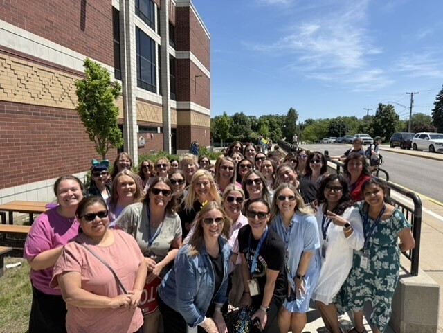 Maercker School staff smile for the camera in front of the building