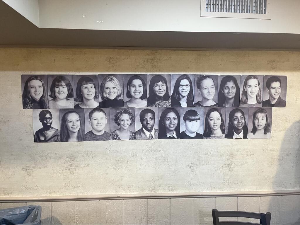 Class of 2001 yearbook photos on a wall