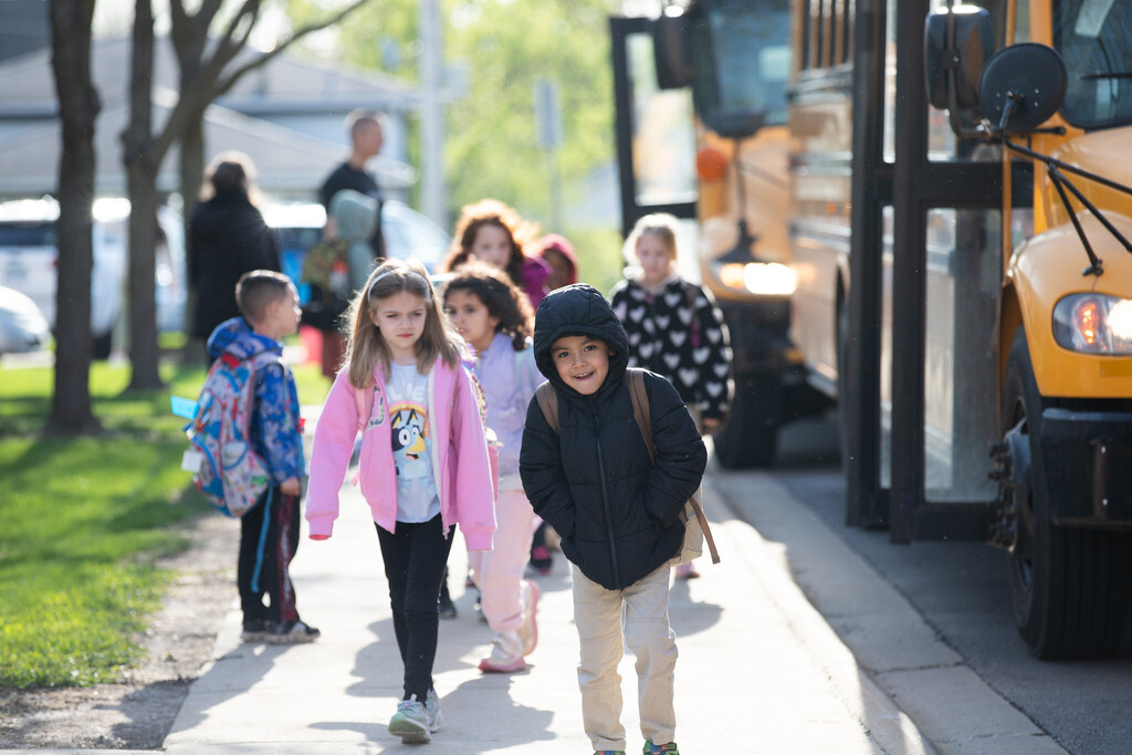 students walk into school from the bus