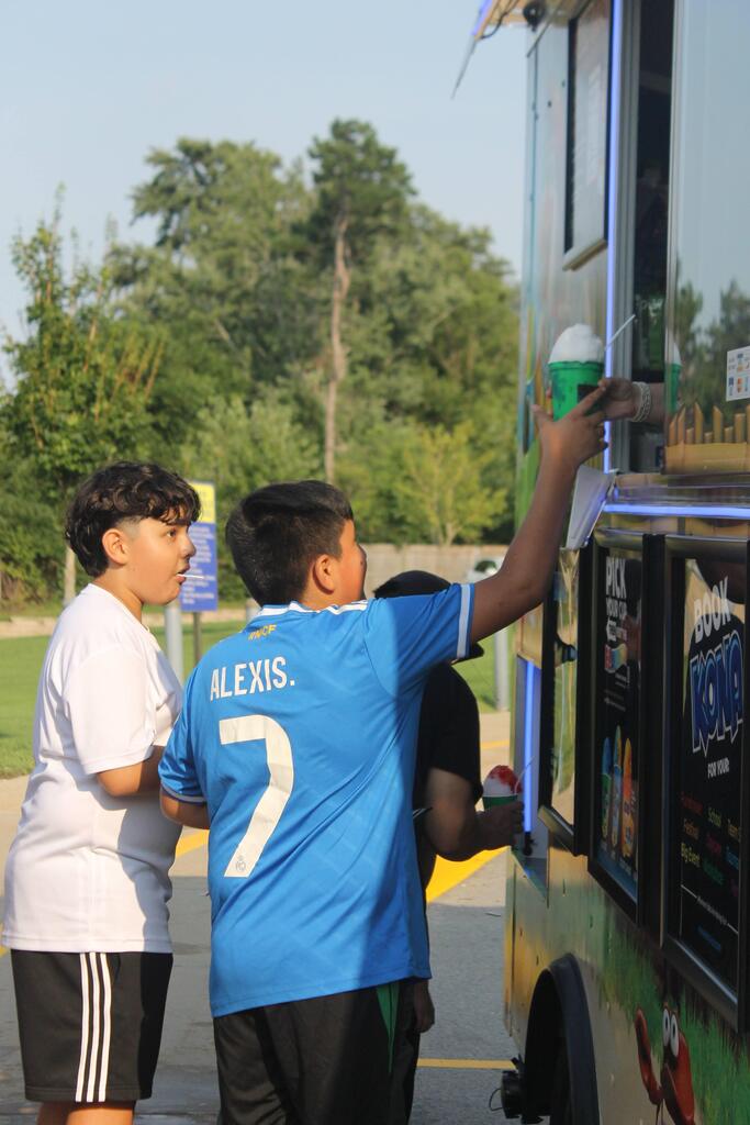A student grabs a snow cone from a food truck