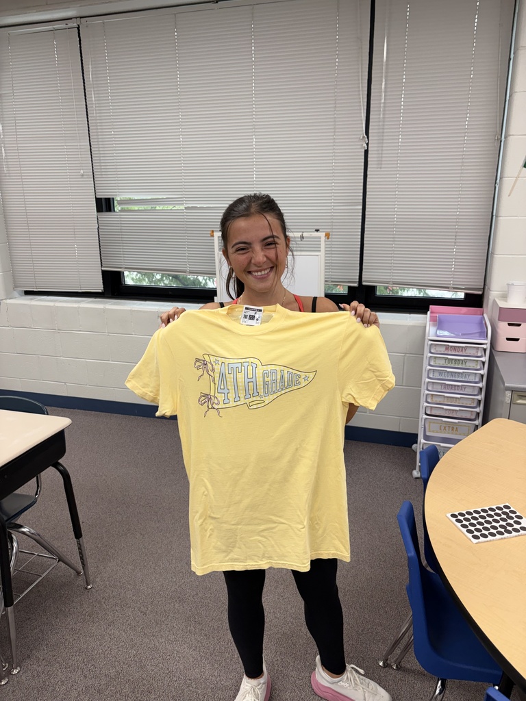 A teacher smiles with a shirt that says "4th grade"
