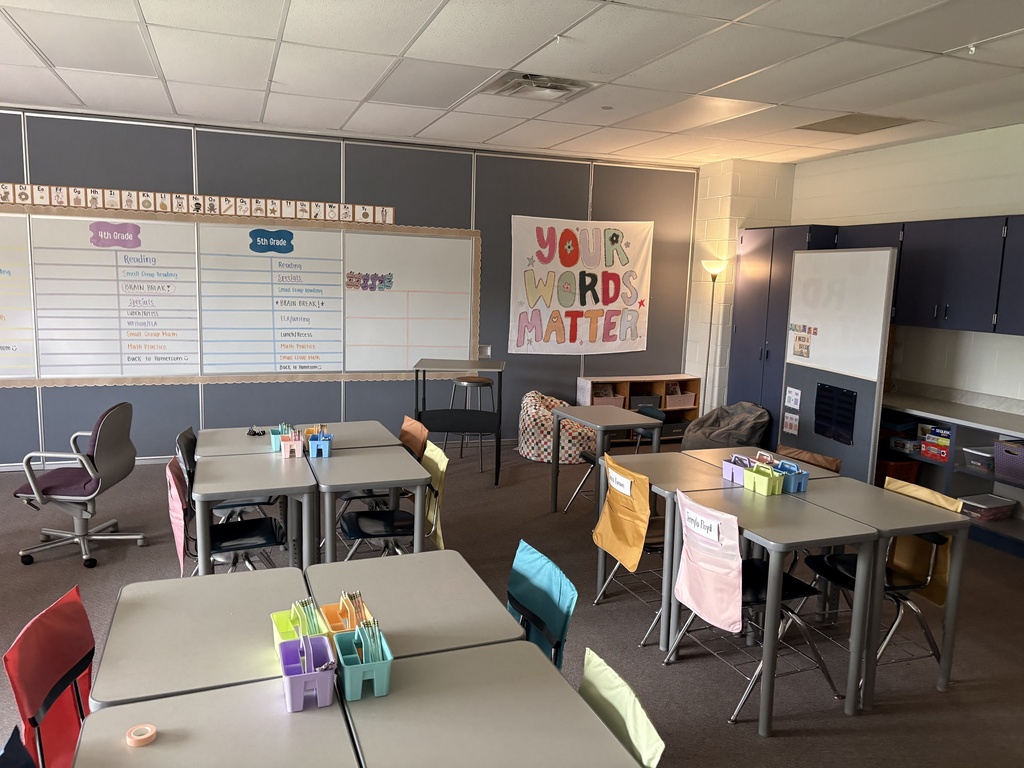 A classroom with desks organized and wall art that says "your words matter"
