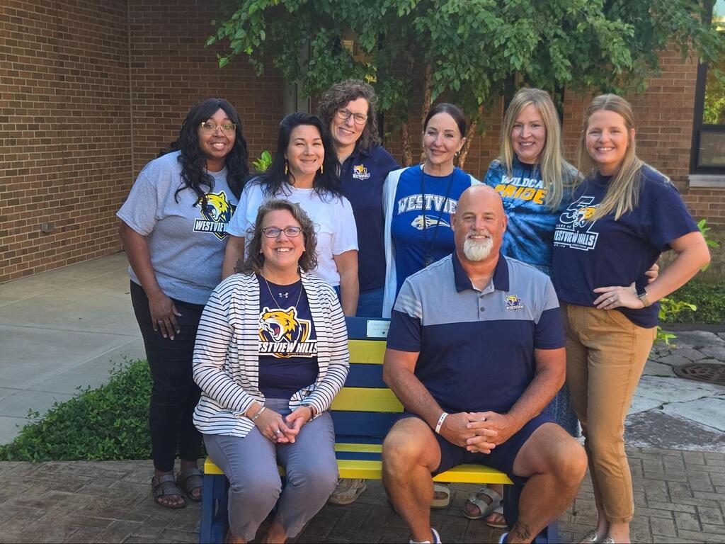 Mr. Goss posing and smiling with other staff members
