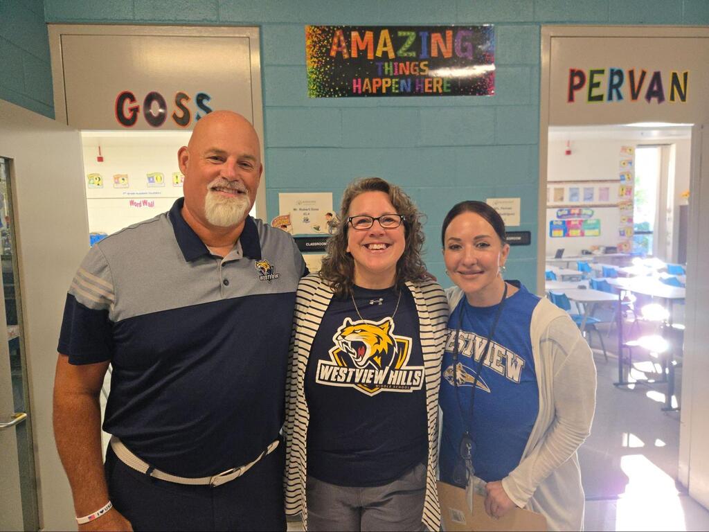 Mr. Goss posing and smiling with other staff members