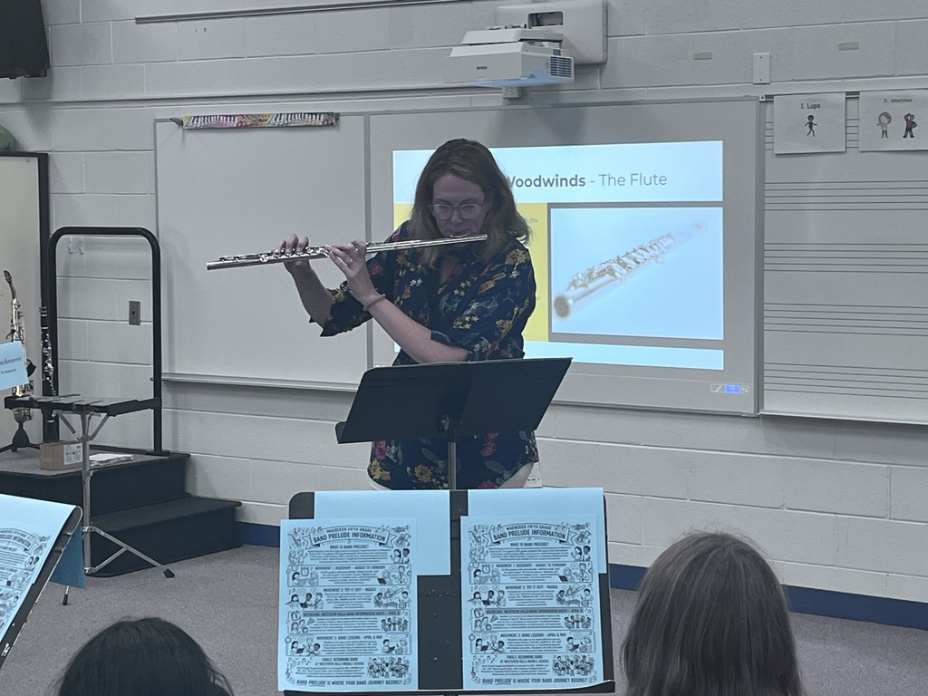 A teacher demonstrates or plays along with students on a woodwind instrument
