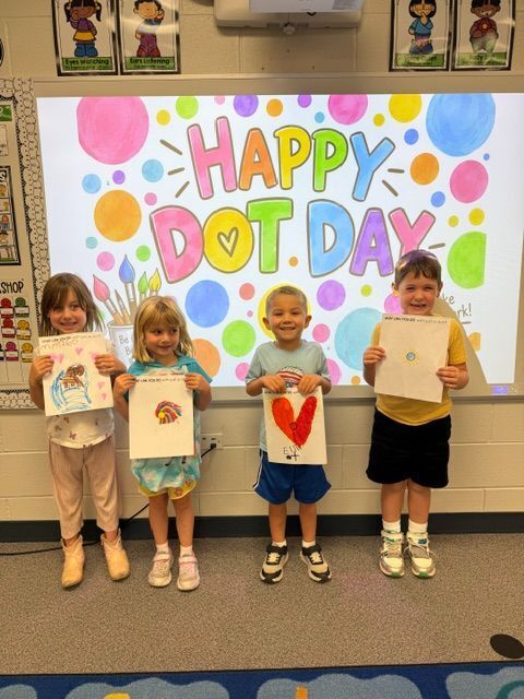 students standing in front of sign that reads happy dot day
