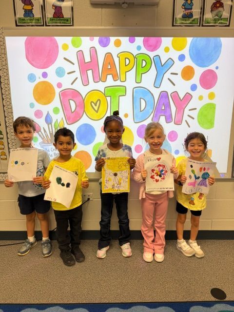 students standing in front of sign that reads happy dot day