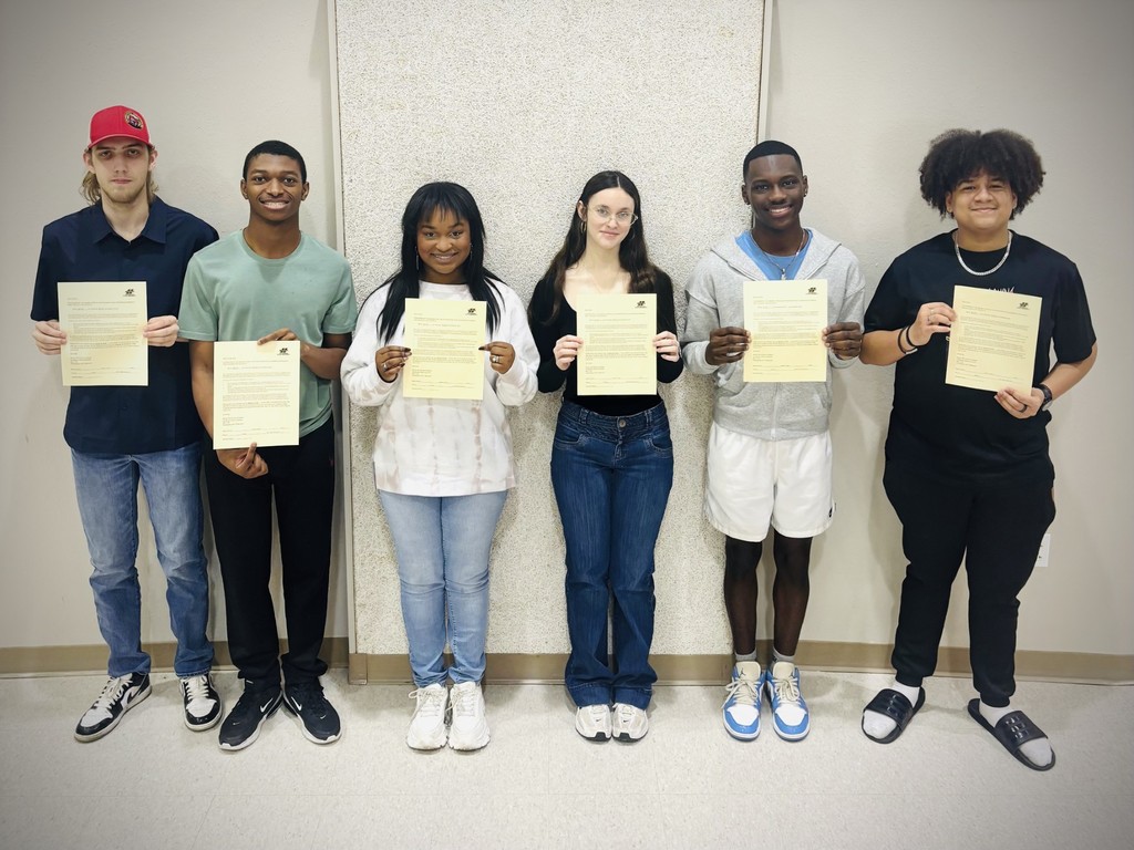 Seniors are shown with their scholarship award letters from left to right: Zac Wilson, Christopher Revels, Ashlyn Gulley, Zoey Robertson, Kearthur Brantley, and Aiden Jones